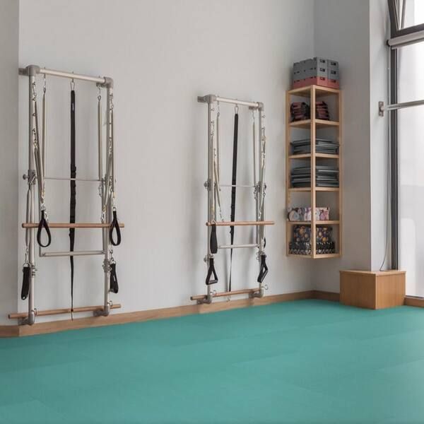 Open studio floor with mats, a low box and resistance bands arranged for a session